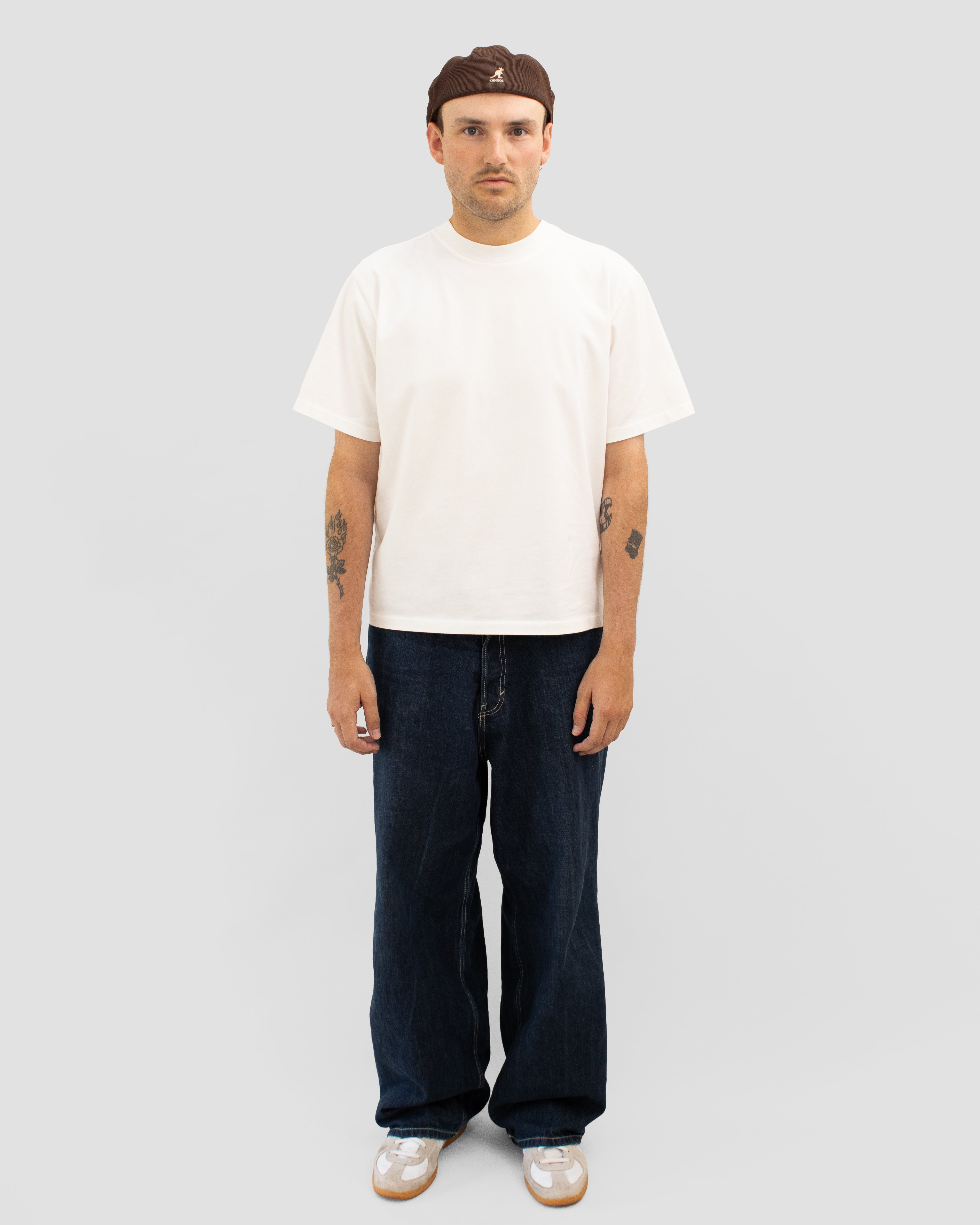 Model wearing Braddyll statement tee in white with cropped fit, french seam and single stitching seen from the front