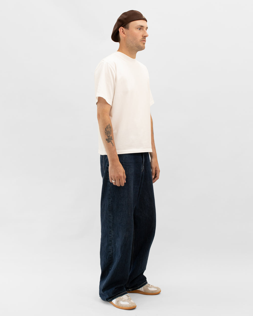 Model wearing Braddyll statement tee in white with cropped fit, french seam and single stitching seen from the side