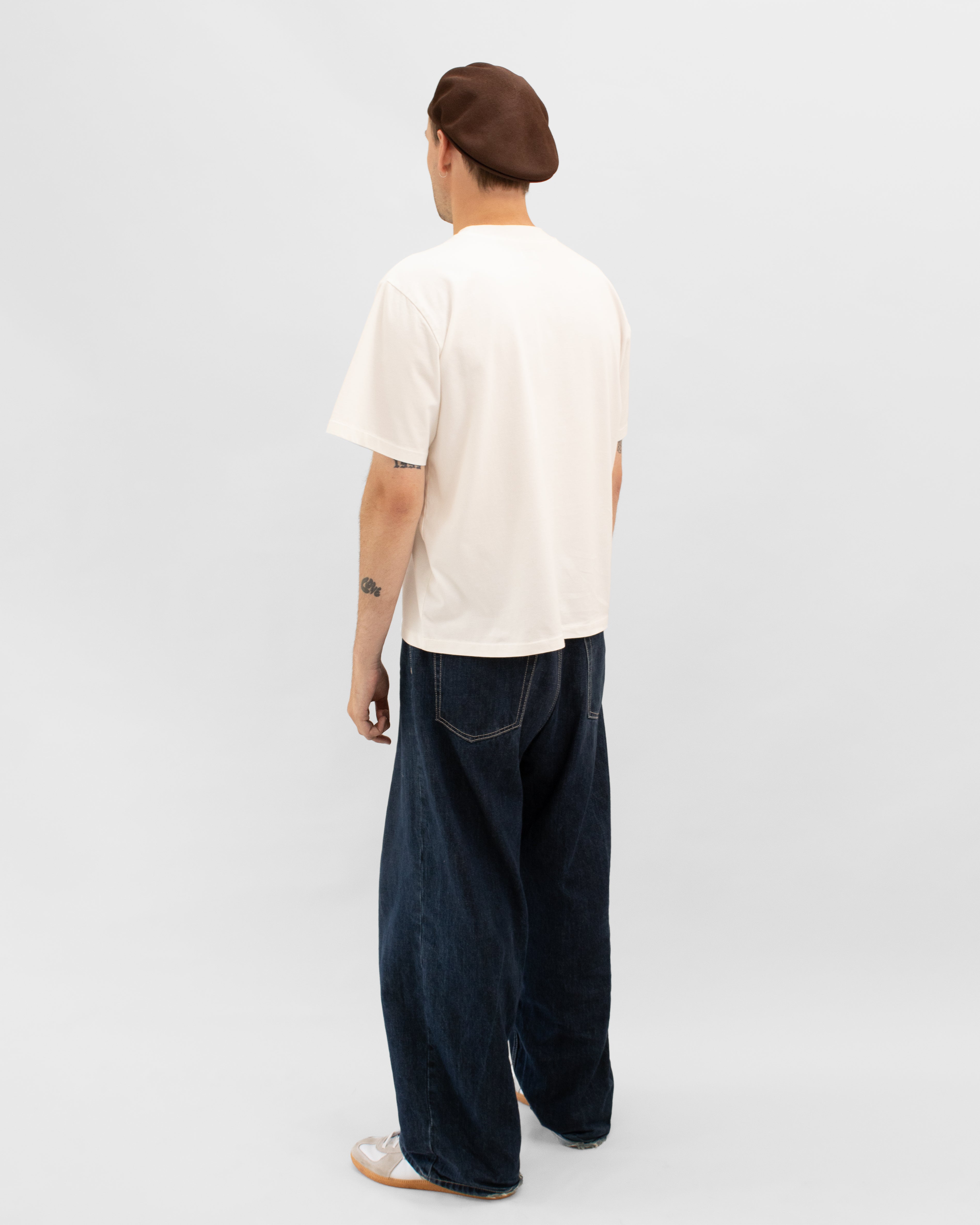 Model wearing Braddyll statement tee with cropped fit, french seam and single stitching seen from behind