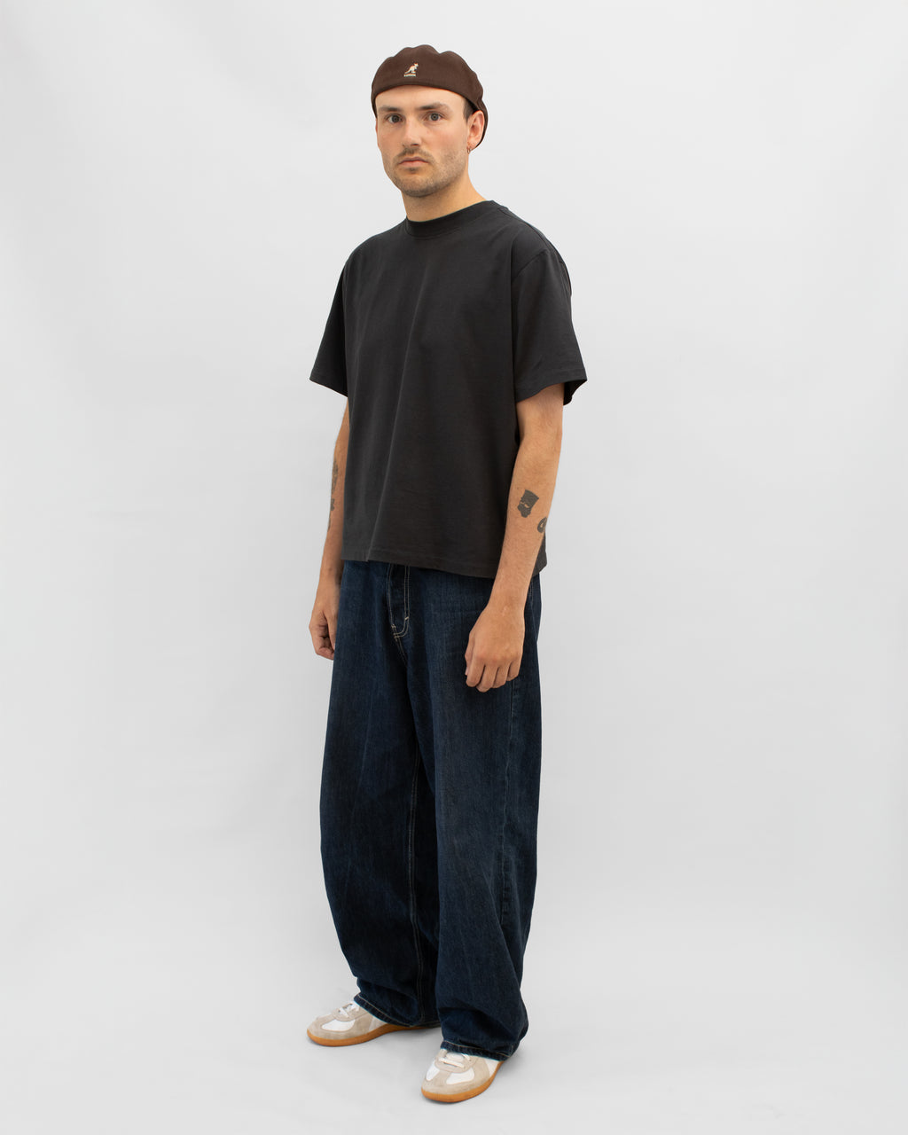 Model wearing Braddyll statement tee in black with cropped fit, french seam and single stitching seen from the side