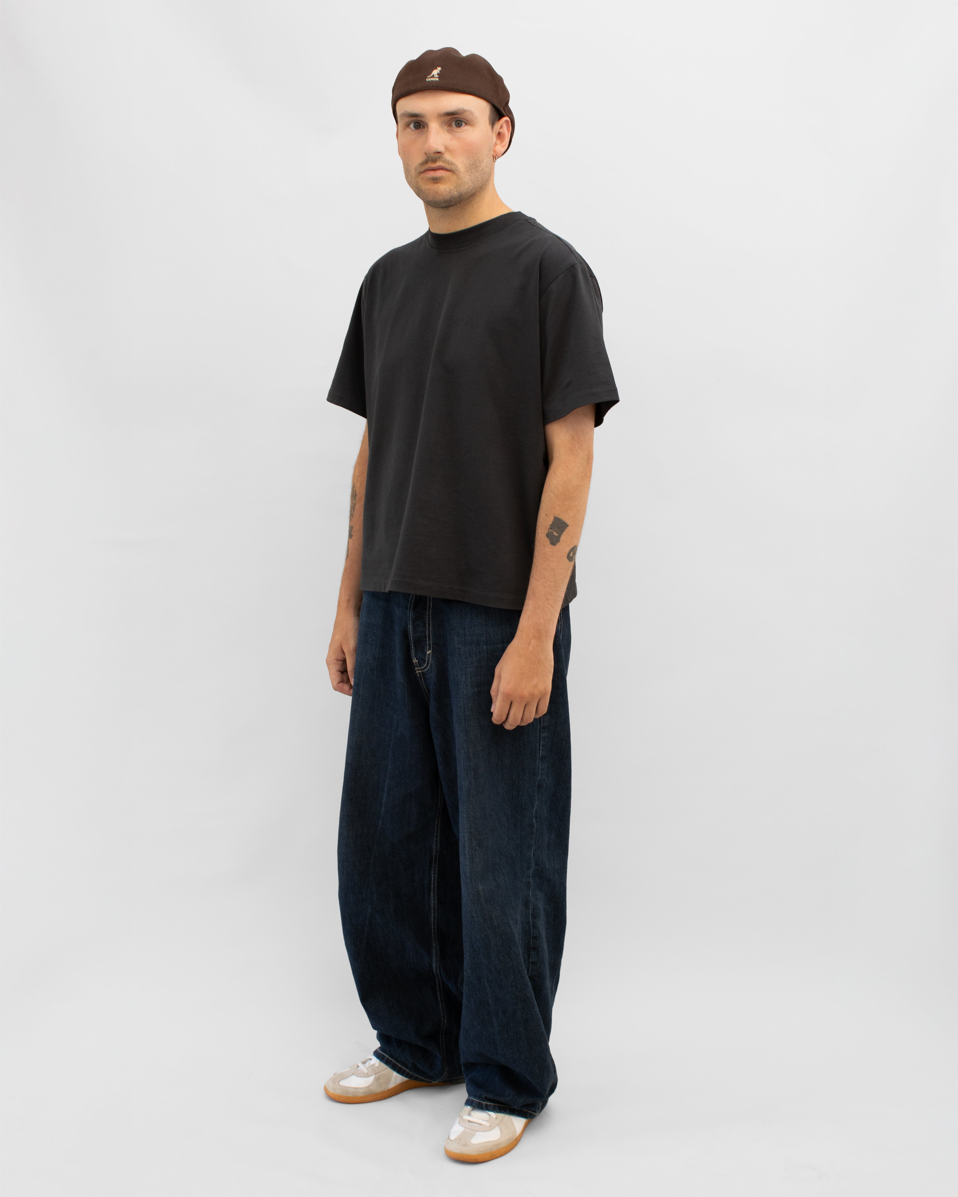 Model wearing Braddyll statement tee in black with cropped fit, french seam and single stitching seen from the side